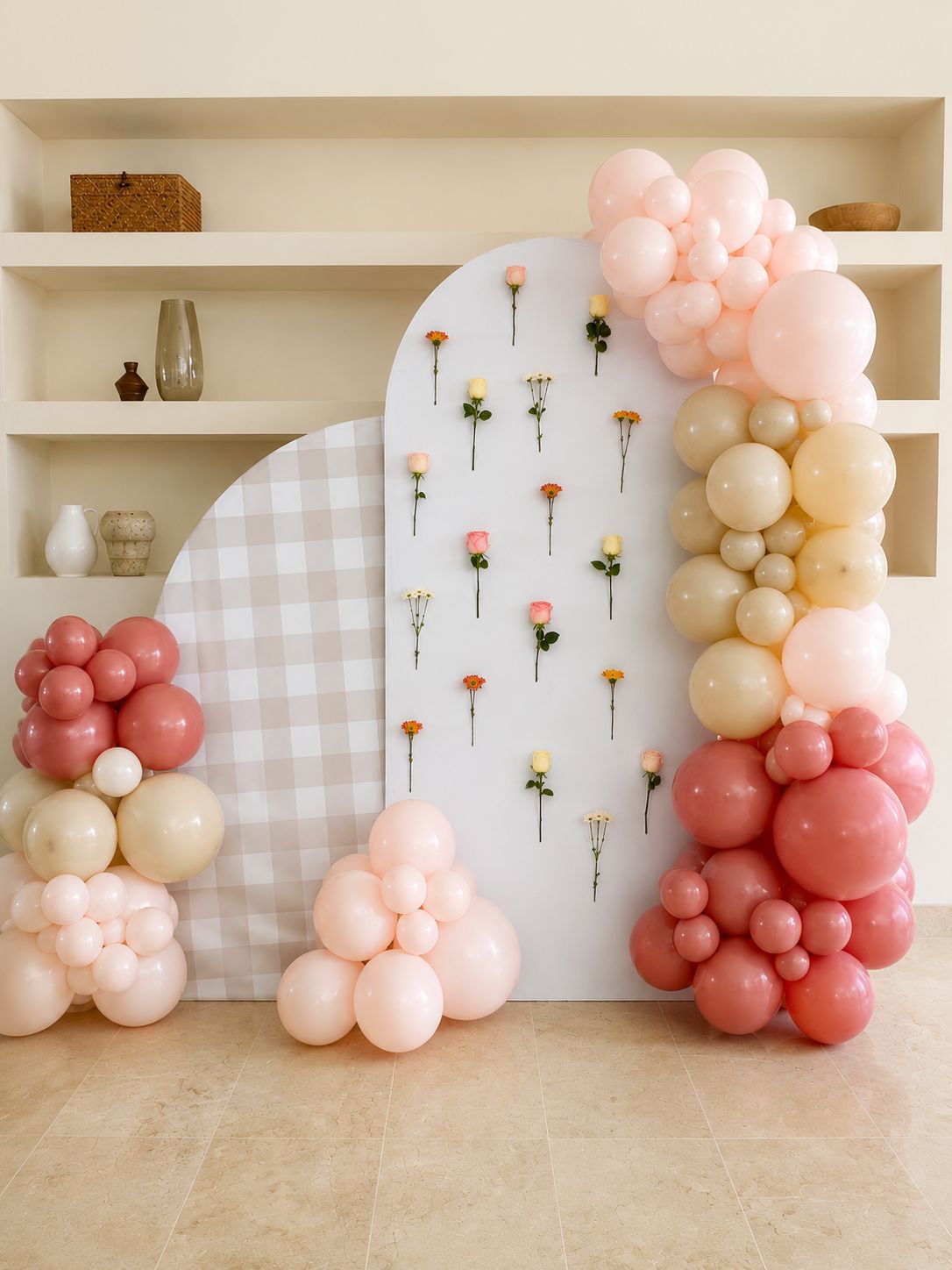 Escenario editorial con flores, paneles y globos en tonos cálidos